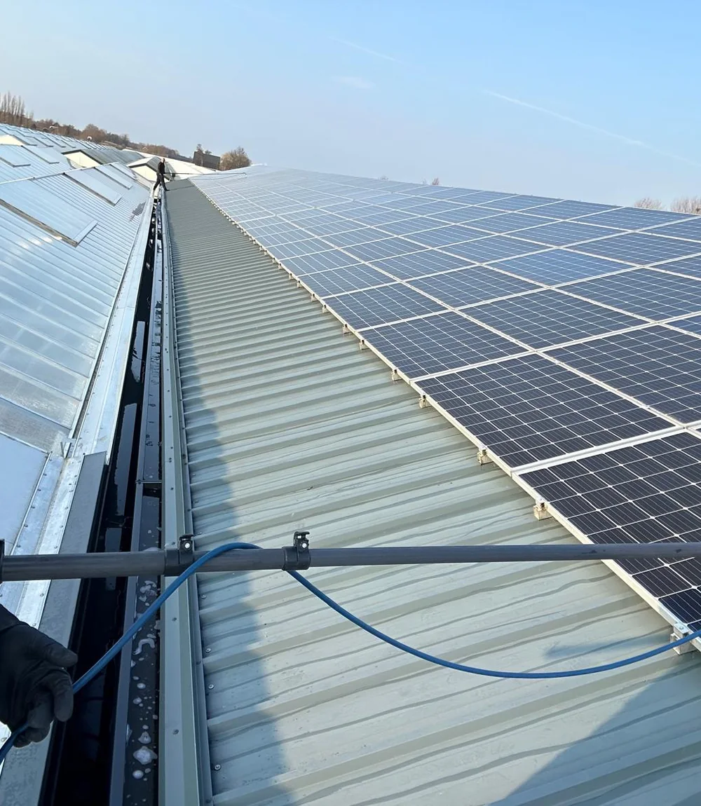 Vakman van Optima reinigt zonnepanelen