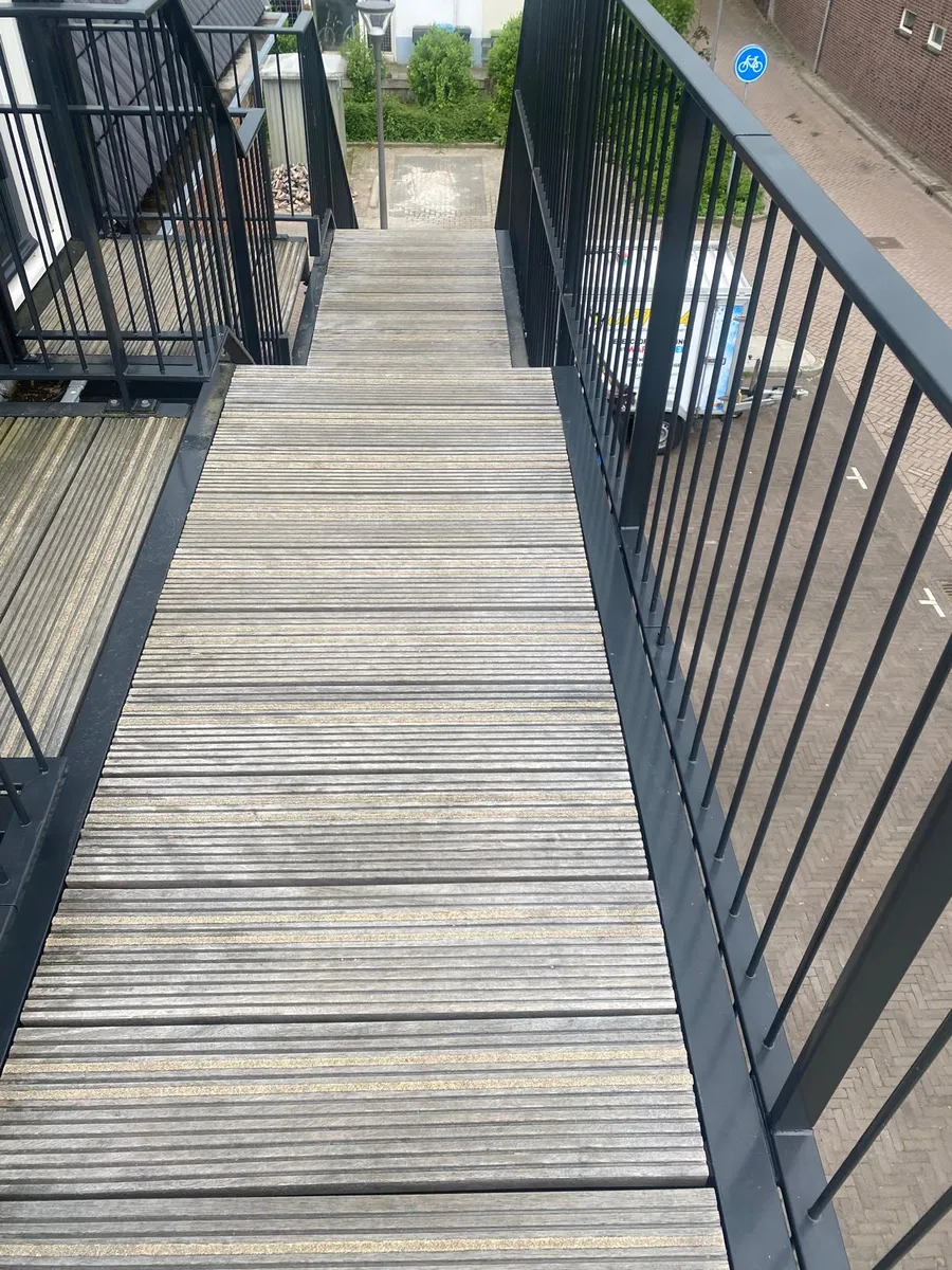 Vergrijsde houten loopbrug vóór reiniging